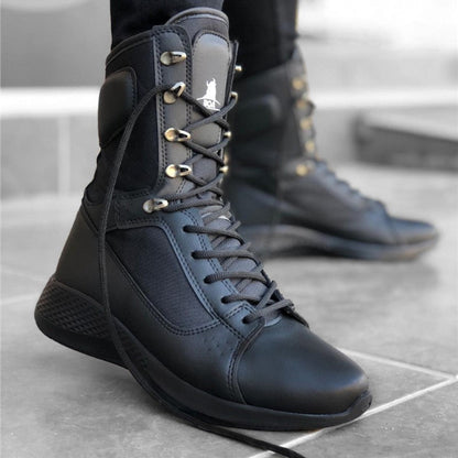 Black high-top sneakers with gold accents on a concrete floor.