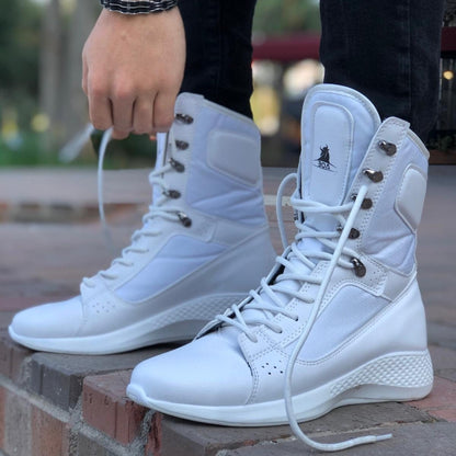White high-top sneakers being worn on a blurred outdoor background